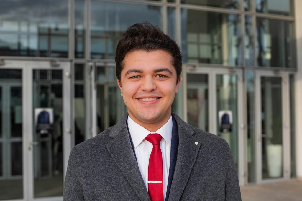man in gray suit jacket smiling